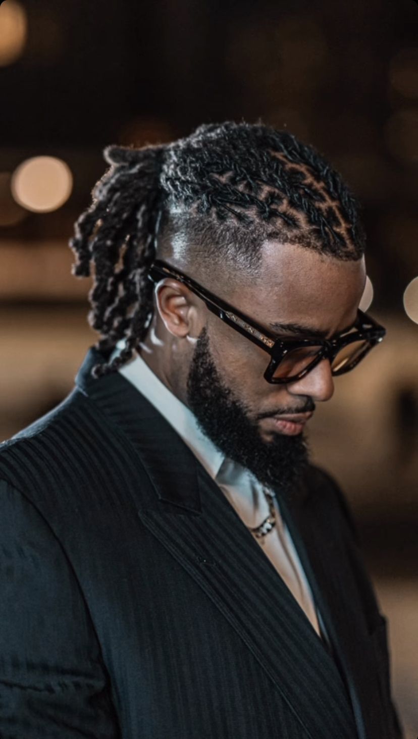 a man in suit with neat locs